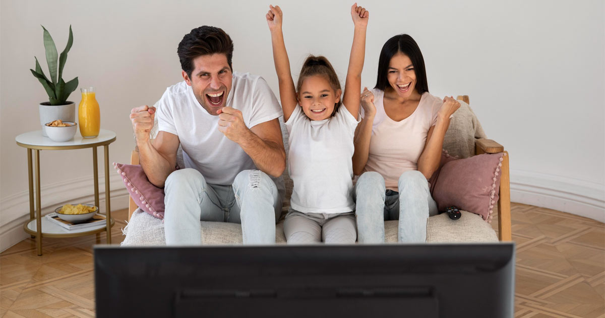 Happy family watching tv at home.