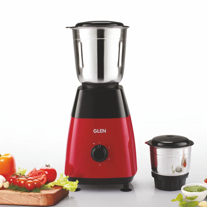 A vibrant red Glen 500W Mixer Grinder with two stainless steel jars displayed on a kitchen counter.